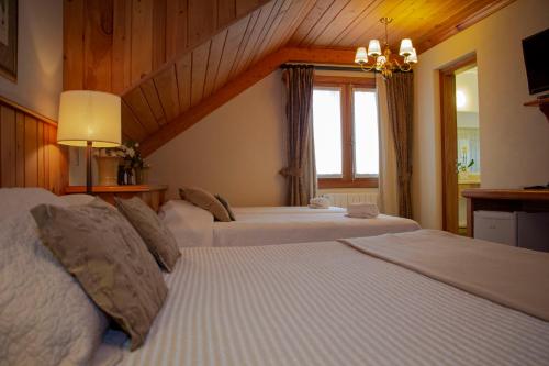 a hotel room with two beds and a window at Hotel Solar d'Izabel in Campos do Jordão
