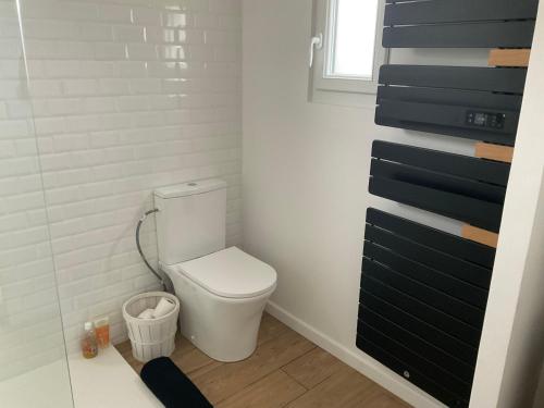 La salle de bains est pourvue de toilettes et d'un mur noir et blanc. dans l'établissement Jolie maison de pêcheur, à Plouguerneau