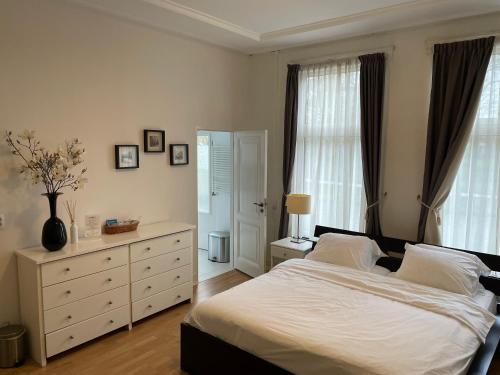 a bedroom with a bed and a dresser and windows at Bed and Breakfast Always Good in Utrecht