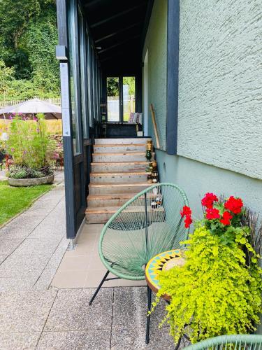 a green bench sitting in front of a building with flowers at Jules&Jim Gästehaus in Linz