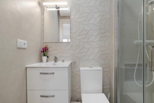 Un baño con inodoro, lavabo y ducha. en Apartamento Maria A, en Vejer de la Frontera
