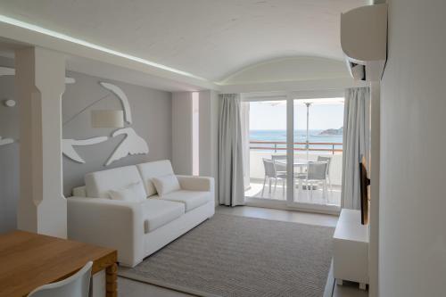 a living room with a white couch and a balcony at MUPA Apartments in Albufeira