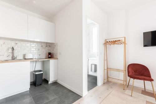 - une cuisine avec une chaise rouge dans la chambre dans l'établissement Studio lumineux Paris Est -II, à Paris