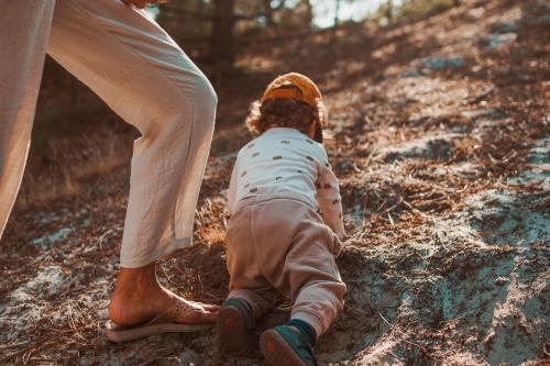 a baby sitting on the ground next to a person at Dutchen Park Weideduyn in Schoorl
