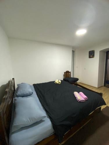 a bedroom with a bed with two slippers on it at Дом в старом тбилиси in Tbilisi City