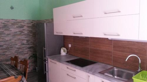 a kitchen with white cabinets and a sink at Apartment Ina in Povlja