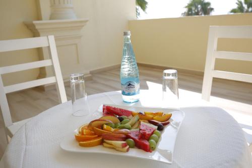 a plate of food and a bottle on a table at Hotel Vila Barbaut in Karpen