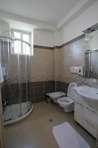 a bathroom with two toilets and a shower and a sink at Hotel Vila Barbaut in Karpen