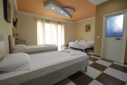 a bedroom with two beds and a large window at Hotel Vila Barbaut in Karpen