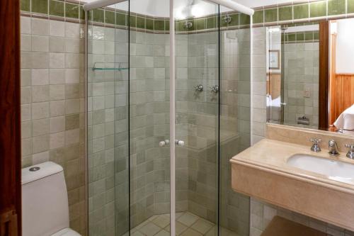 a bathroom with a shower and a toilet and a sink at Hotel Solar d'Izabel in Campos do Jordão