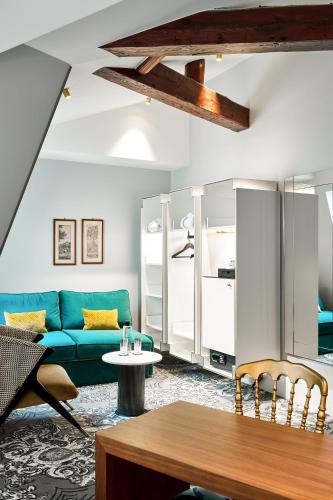 un salon avec un canapé bleu et une table dans l'établissement Normandy Le Chantier, à Paris