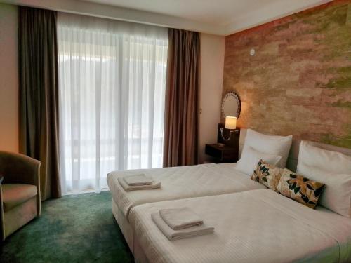a hotel room with a large bed and a window at Orlovo gnezdo in Ljubovija