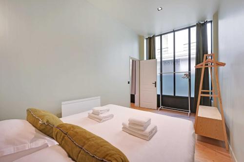 Cette chambre comprend un lit avec une échelle et des serviettes. dans l'établissement Haven of peace-2BR-4P-Near the Palais de Garnier, à Paris