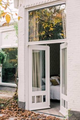 a white door on a house with a bedroom at Garden View City center Villa Tilburg Hendrik in Tilburg