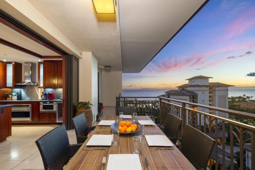 a dining room with a table and a balcony at Ko Olina Beach Villas O1121 in Kapolei