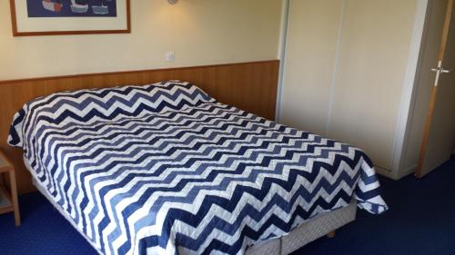 a bed with a black and white comforter in a room at Private Studio - Paris - La Défense in Courbevoie