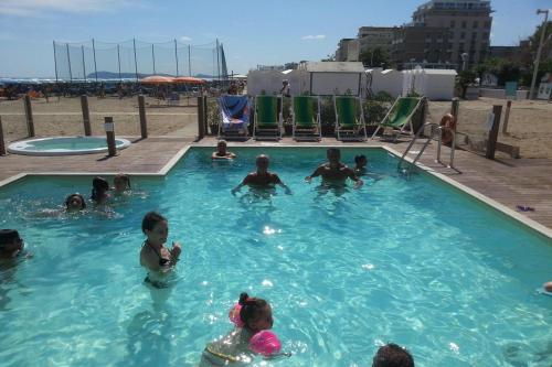 un groupe de personnes dans une piscine dans l'établissement Hotel Tenerife, à Riccione