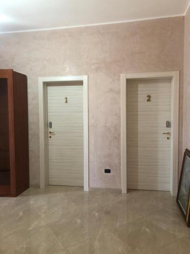 two white doors in a room with a tile floor at Tramonti salentini in San Marzano di San Giuseppe