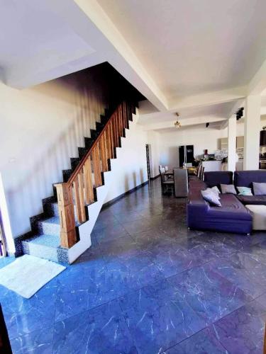 a living room with a couch and a staircase at Villa de luxe Domaine Léna vue sur mer in Foulpointe