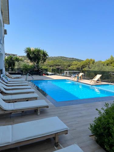 a large swimming pool with lounge chairs next to it at Hotel Vila Park Bujari Ksamil in Ksamil