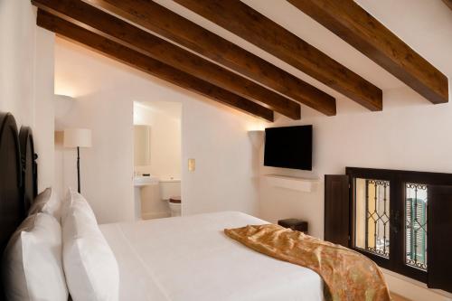 a bedroom with a white bed and a tv at Portella Palma in Palma de Mallorca