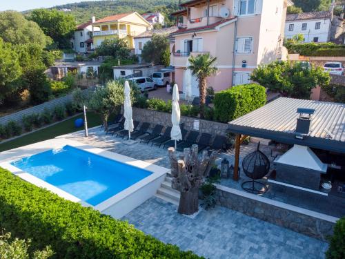 an image of a swimming pool with umbrellas at Apartmani Andiks Dramalj in Dramalj
