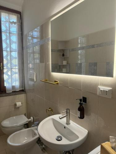 a bathroom with a sink and a toilet and a mirror at ZenZone House in La Spezia