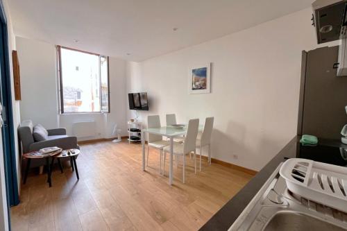 a kitchen and living room with a table and chairs at 1BR in Historic Center of Grasse - BENAKEY in Grasse