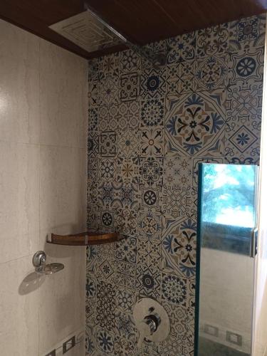 a bathroom with a shower with blue and white tiles at Riviera palms 1 Luxury 1 BHK apartment with Swimmimg Pool view- Arpora - near baga beach in Old Goa