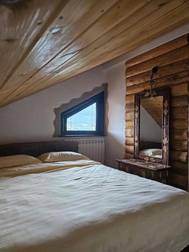una camera da letto con un letto grande e uno specchio di Cabană Urșilor Gosen a Vama