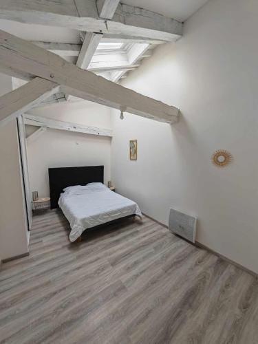 une chambre avec un lit dans une pièce blanche dans l'établissement Gîte de Lubat, à Cézac