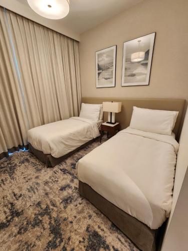 a hotel room with two beds and a window at Solo RealtyHH Apartments - Address Residence Fujairah in Sharm