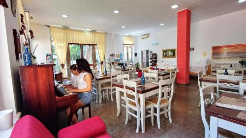 una donna seduta a un tavolo in un ristorante di Borgo Console a Porto Cesareo