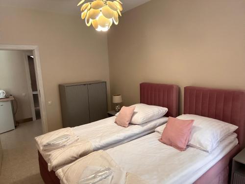 two twin beds in a room with a chandelier at Red Barn in Spała
