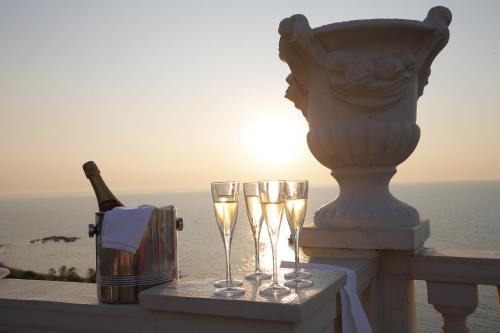 a table with glasses of champagne and a vase at Hotel Vila Barbaut in Karpen