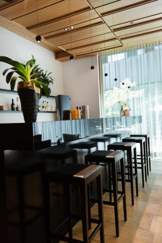 a row of tables and stools in a restaurant at Hotel am See in Hard