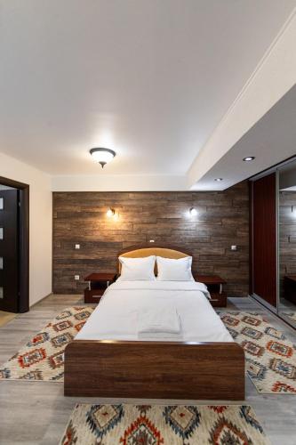 a bedroom with a large bed with a wooden wall at Resort EuroPark Fundata in Fundata