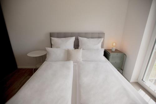 a bed with white sheets and pillows in a room at Ferienhaus am Mühlenweiher im Allgäu in Leutkirch im Allgäu