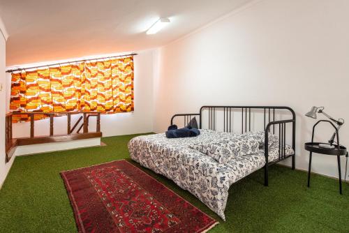a bedroom with a bed and a window and a rug at Cantinho alegre em Cascais in Cascais
