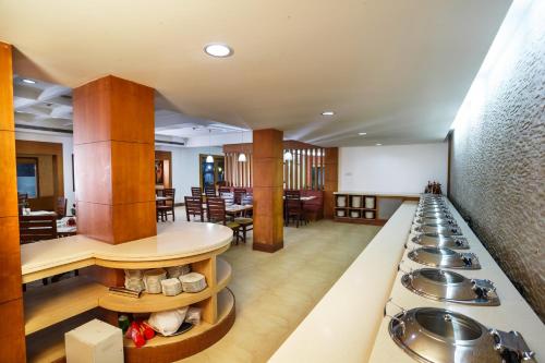 a cafeteria with a row of sinks and tables at Hotel Elite Palazzo in Kāladi
