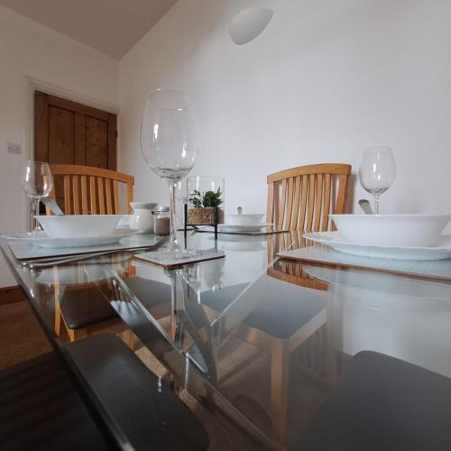 a dining room with a glass table and chairs at Huge 4 bed in the heart of Kettering in Kettering