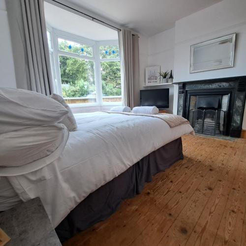 a bedroom with a large bed and a fireplace at Huge 4 bed in the heart of Kettering in Kettering
