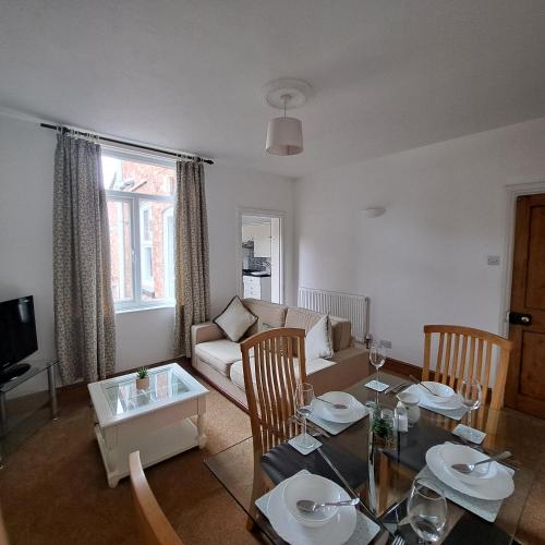 a living room with a table and a couch at Huge 4 bed in the heart of Kettering in Kettering