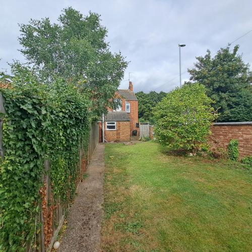 a fence in front of a house with a yard at Huge 4 bed in the heart of Kettering in Kettering