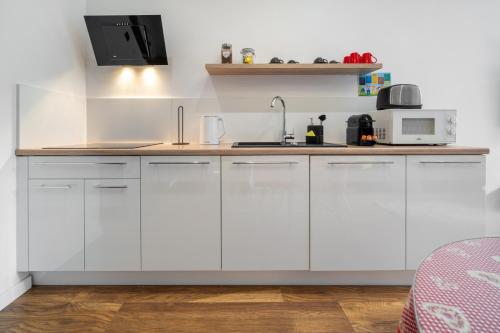 a kitchen with white cabinets and a microwave at WILLA JAROSTA & SPA, AC -free parking in Zakopane