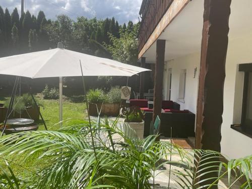 a large white umbrella in a yard with plants at Birkenhof in Taching am See