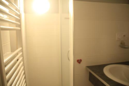 - une salle de bains blanche avec lavabo et lumière dans l'établissement Chalet de lOy OY16 NATURE & MOUNTAIN 4 Pers, à Châtel