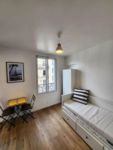 - un salon avec un canapé, une table et un réfrigérateur dans l'établissement Superbe studio à MONTMARTRE, à Paris