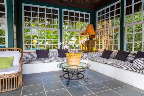 a living room with couches and a glass table at Pousada do Príncipe in Paraty