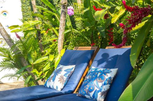 a blue couch with two pillows next to a pot of flowers at Pousada do Príncipe in Paraty